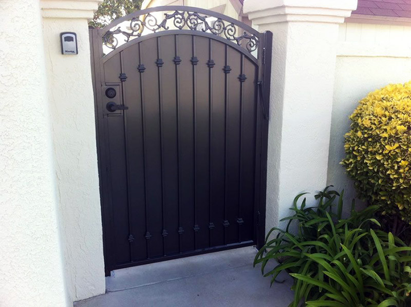 درب حیاط فلزی به رنگ سیاه و دیوار محوطه سفید