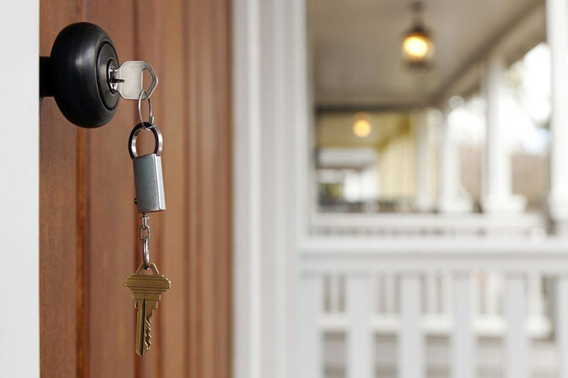 دسته کلید آویزان از قفل درب ورودی چوبی خانه