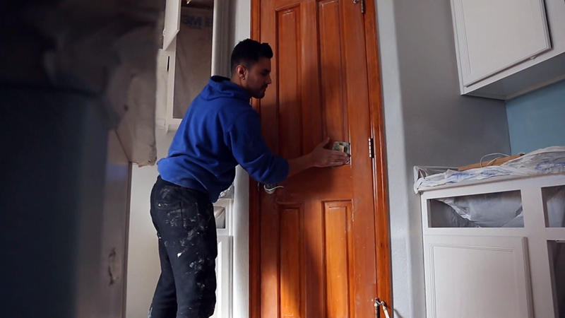 قبل از نقاشی درب چوبی باید همه بخش‌های درب را با دقت سنباده بزنید.