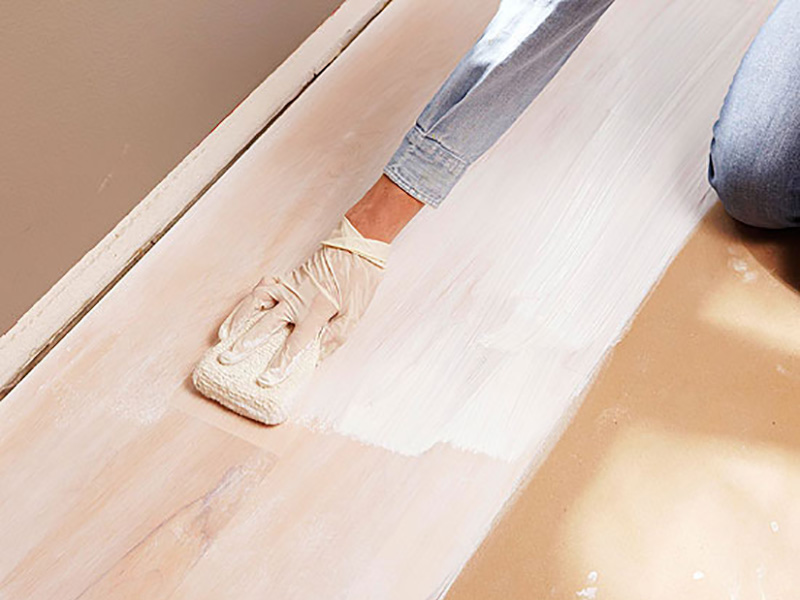 برای سفید کردن کف‌پوش چوبی یک اسفنج تمیز بردارید و آن را آغشته به رنگ سفید کنید و یک لایه نازک از رنگ را روی آن بکشید.