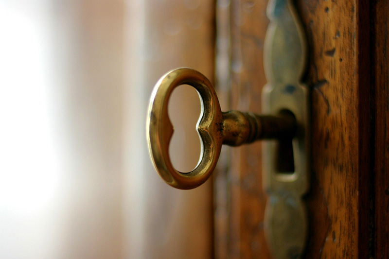 یک کلید طلایی داخل قفل در چوبی اتاق خواب قدیمی