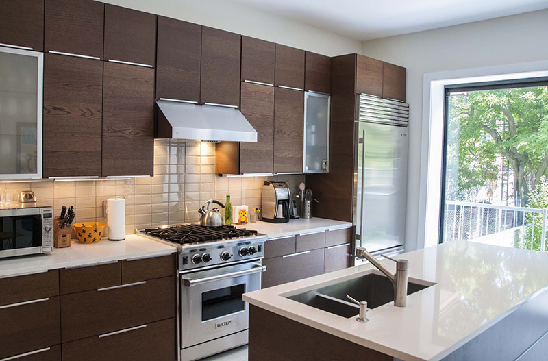 نمایی از یک آشپزخانه با کابینت ام دی اف روکش‌دار طرح چوب قهوه‌ای